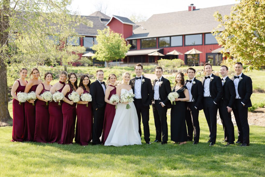 Wedding party portrait at Fishermen’s Inn with burgundy bridesmaid dresses and black tuxedos