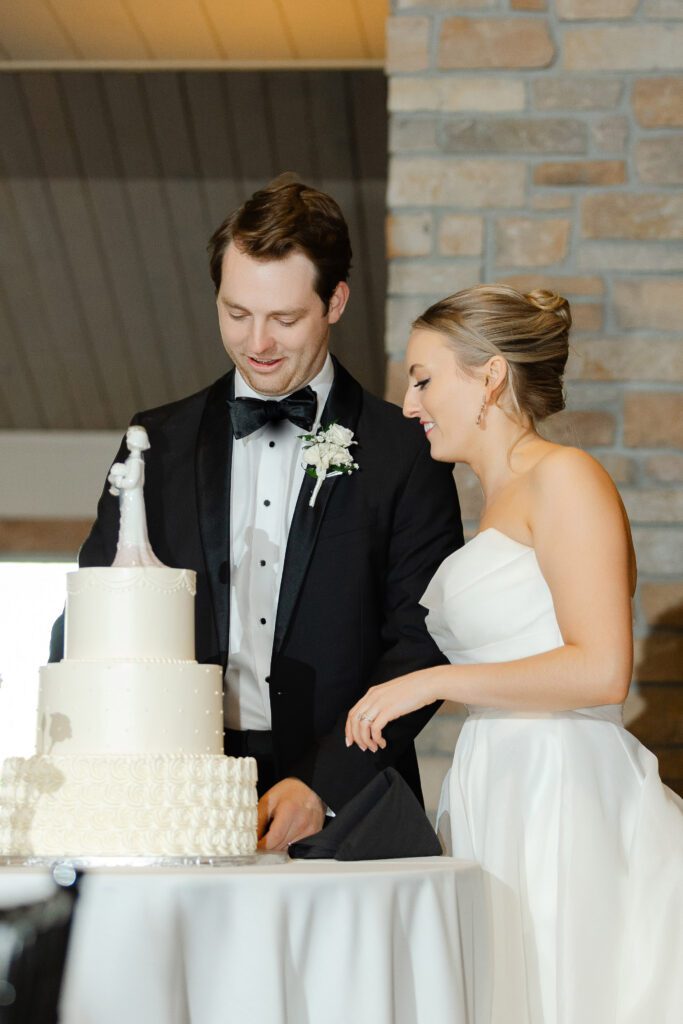 Bride and groom cut their three-tier wedding cake