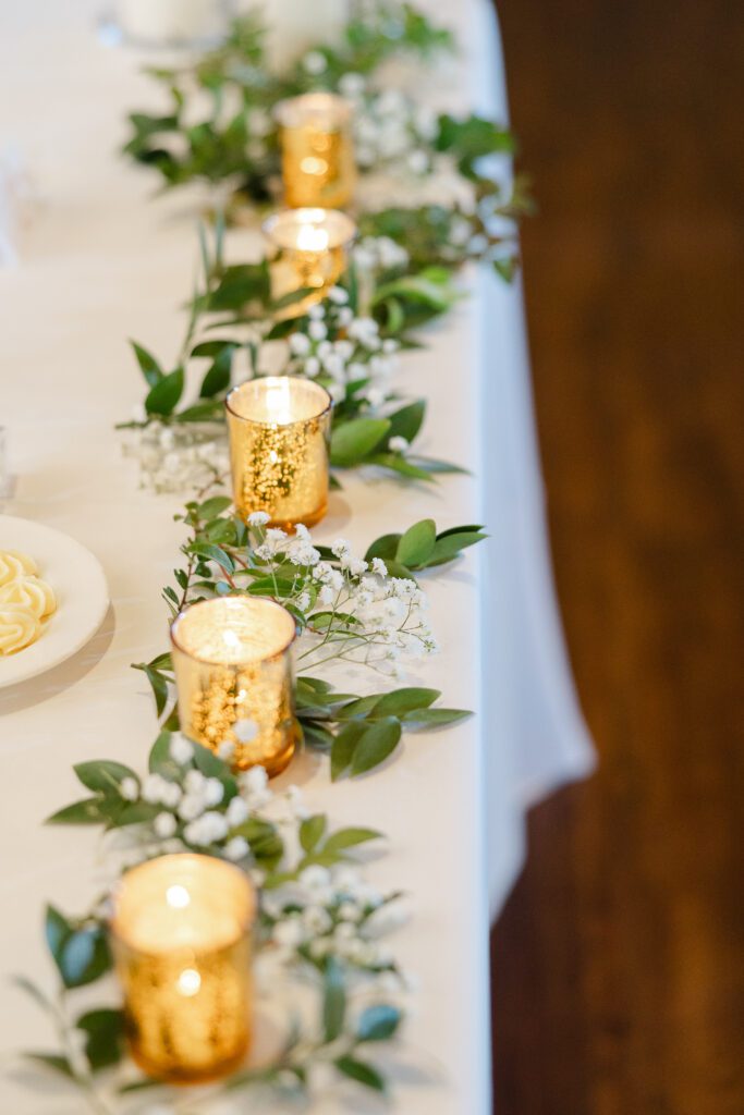 Elegant table setting with candles and greenery.