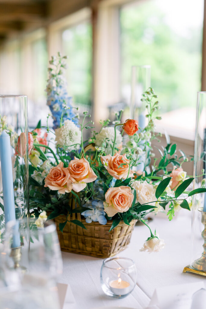 Reception table centerpiece with pastel florals, candles, and garden-inspired décor at Fishermen's Inn wedding venue.
