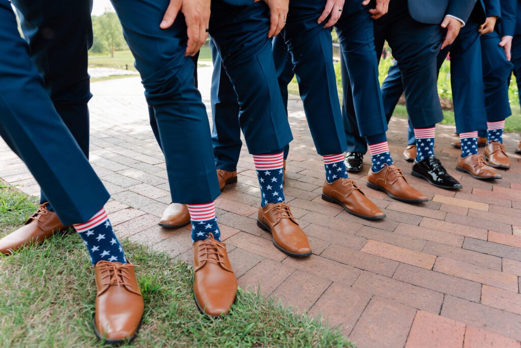 Ricky and his groomsmen showing their american flag print socks during the wedding day at Fishermen’s Inn