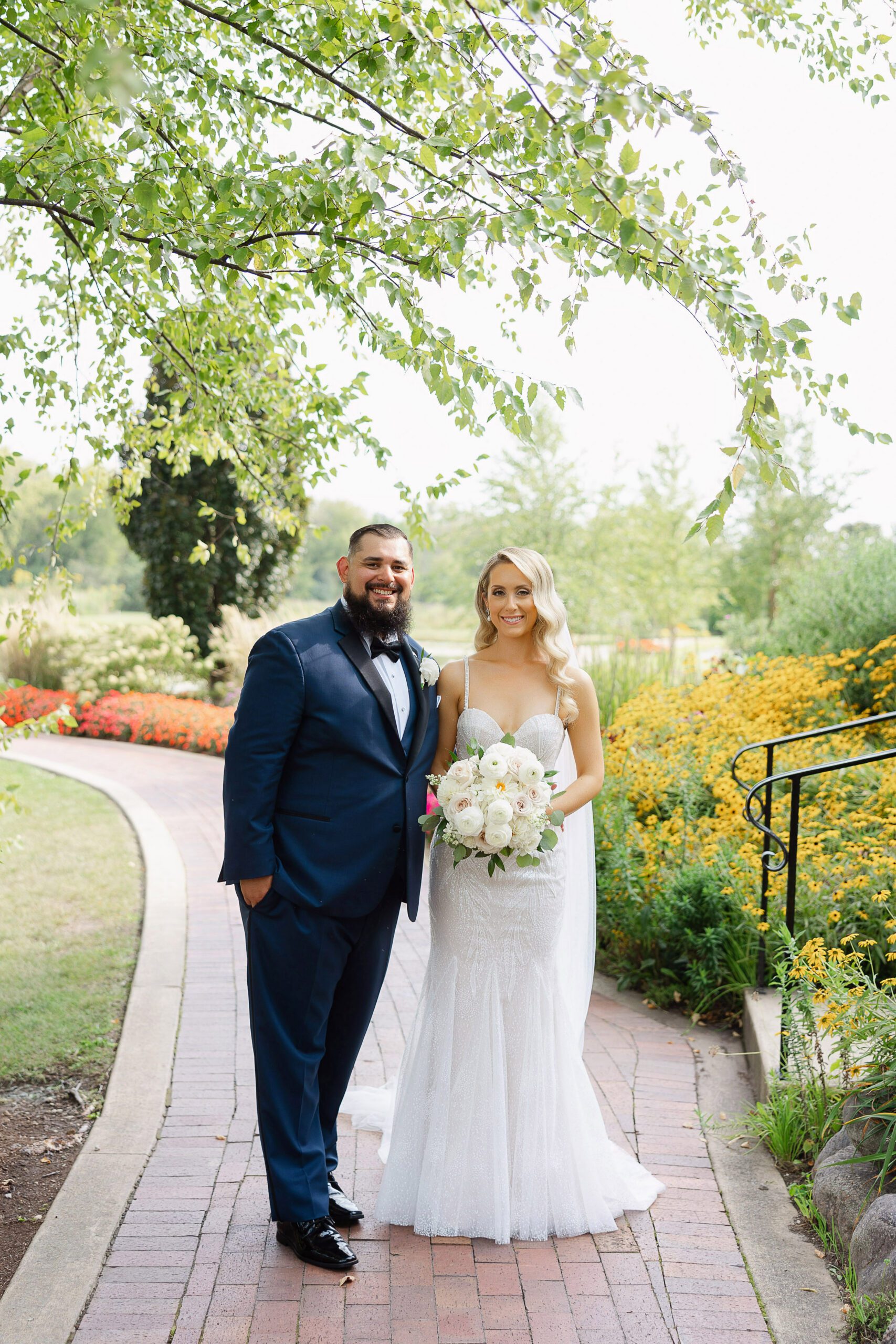 Linda and Ricky surrounded by colorful summer gardens on their wedding day at Fishermen’s Inn