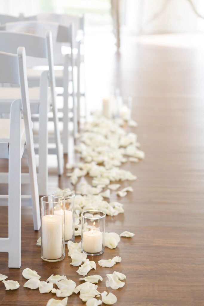 White flower petals and candles decorating the ceremony space at Fishermen’s Inn