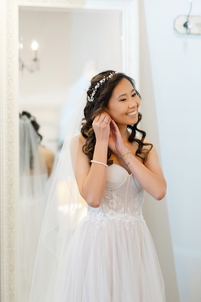 Tina puts on her earrings while getting ready for her Fishermen’s Inn wedding.
