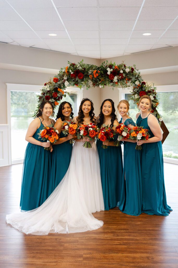 Tina and her bridesmaids pose with colorful bouquets and teal dresses at Fishermen’s Inn.