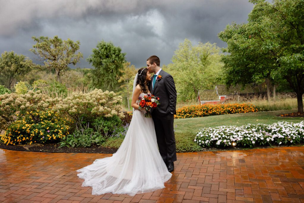 Tina and Connor kiss in the Fishermen’s Inn gardens beneath dramatic storm clouds.