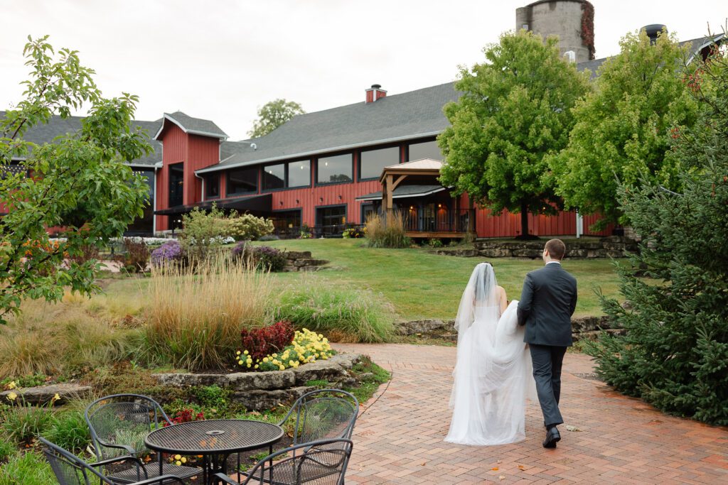 Tina and Connor walk through the gardens with the Fishermen’s Inn barn behind them.